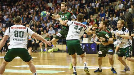 Füchse-Spieler Steffen Fäth ist mit dem Ball in der Hand auf der Suche nach einem Mitspieler. 