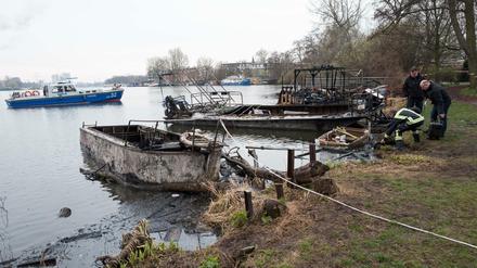 Polizeibeamte untersuchen ausgebrannte Boote am 23.03.2017 am Ufer der Rummelsburger Bucht in Berlin.