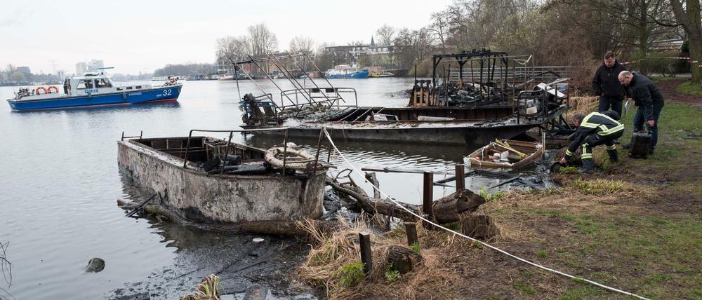 Polizeibeamte untersuchen ausgebrannte Boote am 23.03.2017 am Ufer der Rummelsburger Bucht in Berlin.