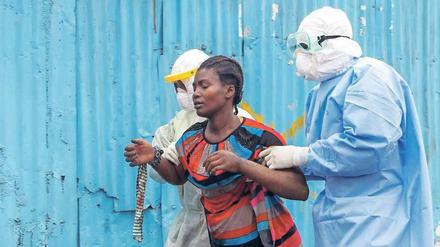 Krankenpfleger begleiten eine Ebola-Patientin in ein Behandlungszentrum in Liberia im Jahr 2014. Liberia wurde als letztes Land überhaupt im Januar 2016 für frei von Ebola erklärt. 