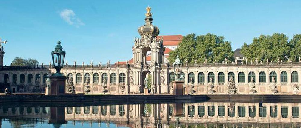 Morgenstimmung. Das Kronentor des Zwingers spiegelt sich im Wasserbecken eines Springbrunnens.