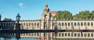 Morgenstimmung. Das Kronentor des Zwingers spiegelt sich im Wasserbecken eines Springbrunnens.