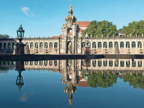 Morgenstimmung. Das Kronentor des Zwingers spiegelt sich im Wasserbecken eines Springbrunnens.