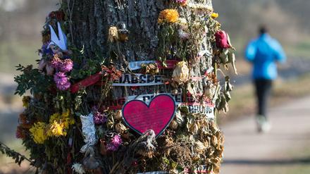 Blumen und Trauerschmuck hängen in Freiburg an einem Baum an der Dreisam.