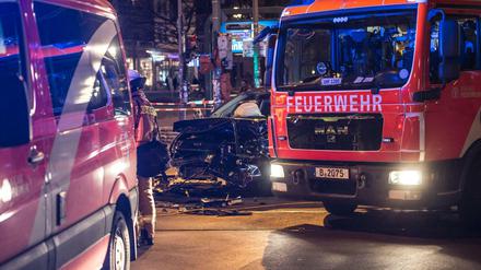 Ein zerstörter Pkw steht am 27.03.2017 in Berlin am Frankfurter Tor zwischen zwei Einsatzfahrzeugen der Polizei.