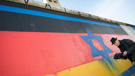 Der Künstler Günther Schaefer restaurierte 2015 an der East Side Gallery in Berlin sein Werk "Vaterland". Das Bild war mit antisemitischen Parolen beschmiert worden.
