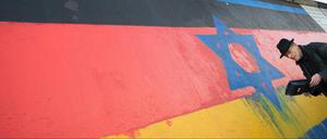 Der Künstler Günther Schaefer restaurierte 2015 an der East Side Gallery in Berlin sein Werk "Vaterland". Das Bild war mit antisemitischen Parolen beschmiert worden.