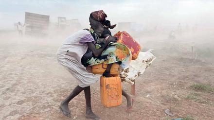 Im UN-Flüchtlingslager Malakal im Südsudan versuchen zwei Mädchen, sich vor einem Sandsturm in Sicherheit zu bringen.