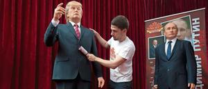 Ein Ausstellungsmitarbeiter entfernt in Sofia (Bulgarien) Fussel von einer Wachsfigur, die US-Präsident Donald Trump (l) darstellen soll. Rechts eine Wachsfigur von Wladimir Putin.