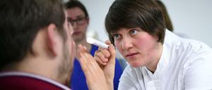 Eine Medizinstudentin blickt einem Patienten ins Auge.