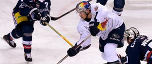 Münchens Frank Mauer (M) versucht, den Puck vorbei an Berlins Frank Hördler (l), Kyle Wilson (r) und Bruno Gervais zu spielen. 