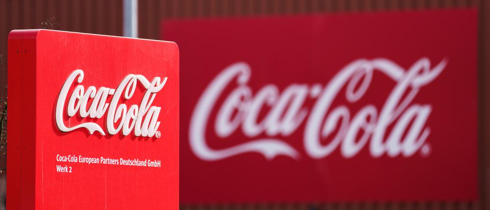 Das Coca-Cola Logo ist an der Fassade einer Produktionshalle angebracht.
