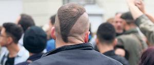 Deeskalationsfrisur. Ein Polizist einer Hundertschaft mit punkigem Kurzhaarschnitt beobachtet Demoteilnehmer 2013 in Kreuzberg.
