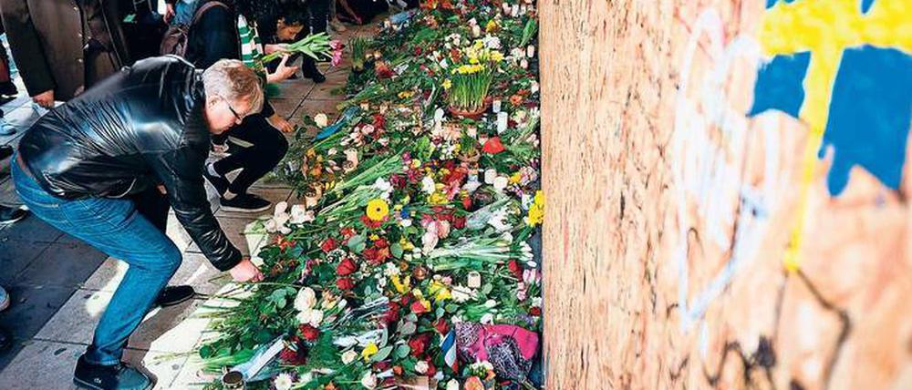 Gedenken in Schwedens Hauptstadt. Passanten legen am Tatort in der Innenstadt Blumen nieder. 