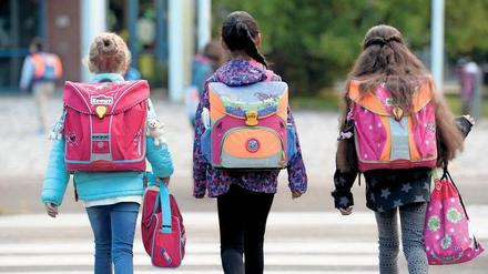 Viel zu schleppen. Kinder auf dem Weg zur Schule.