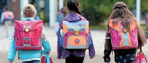 Viel zu schleppen. Kinder auf dem Weg zur Schule.