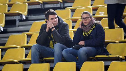 Zwei BVB-Fans sitzen nach der Spielabsage im Stadion.