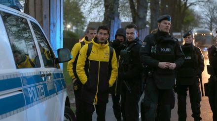 Die BVB-Spieler Nuri Sahin und Matthias Ginter warten nach dem Anschlag auf den Dortmunder Mannschaftbus neben Polizisten. 