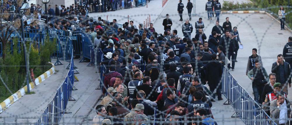Polizisten und Wahlhelfer tragen in Diyarbakir Taschen mit Stimmzetteln in Richtung eines Gerichtsgebäudes.