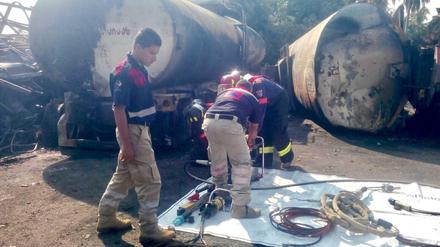 Feuerwehrmänner überprüfen die Überreste des Lkw. 