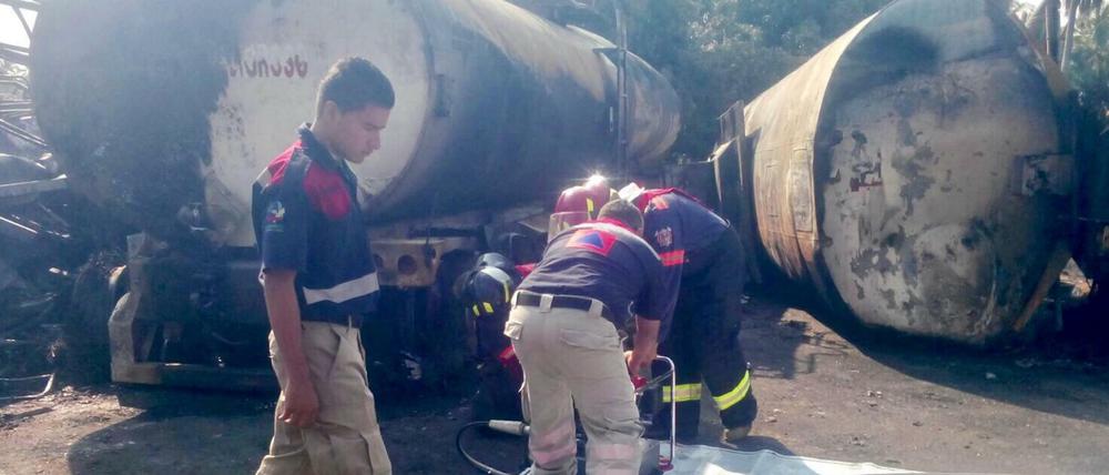 Feuerwehrmänner überprüfen die Überreste des Lkw.