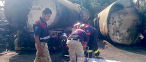 Feuerwehrmänner überprüfen die Überreste des Lkw. 