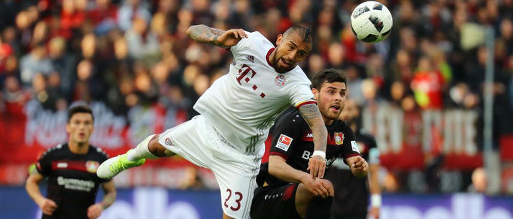 Bayerns Arturo Vidal liegt gut in der Luft. Kevin Volland versucht, für Leverkusen dagegen zu halten.