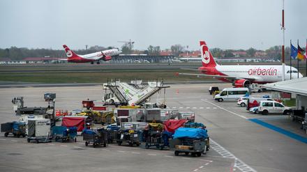 Zahlreiche mit Gepäckstücken beladene Gepäcktransportwagen stehen am 04.04.2017 auf dem Vorfeld am Flughafen Tegel in Berlin. 