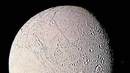 Schneeballmond. Enceladus, ein Saturnmond, ist von einer globalen Eisschicht umgeben. Hydrothermalquellen darunter könnten Leben ermöglichen. 