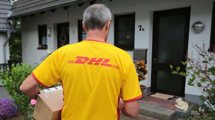 Ein DHL-Paketzusteller der Deutschen Post liefert in Königswinter (Nordrhein-Westfalen).