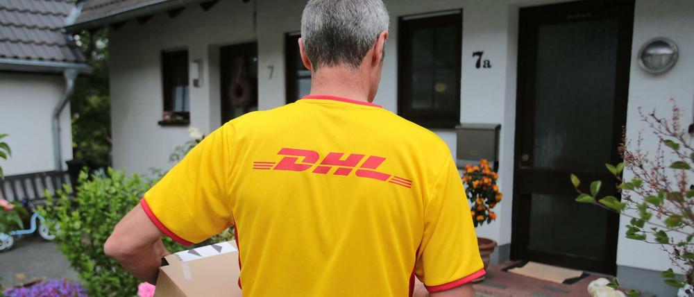Ein DHL-Paketzusteller der Deutschen Post liefert in Königswinter (Nordrhein-Westfalen).