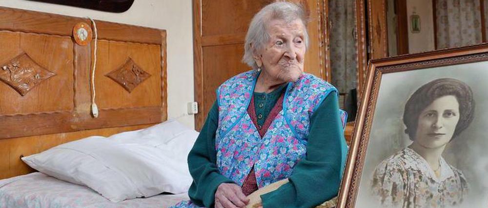 Die Italienerin neben einem Foto, das sie als junge Frau zeigt. 