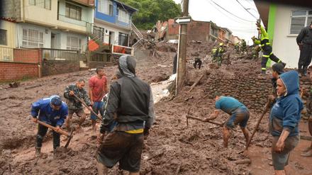 Bewohner der Stadt Manizales, im Westen Kolumbiens, helfen am Mittwoch bei den Räumungsarbeiten nach dem Erdrutsch, der in der Nacht acht Tote hinterließ. Um die 20 Menschen werden noch vermisst.