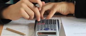 Ein Schüler tippt auf einem Taschenrechner herum. Zu sehen sind seine Hände und der Rechner.