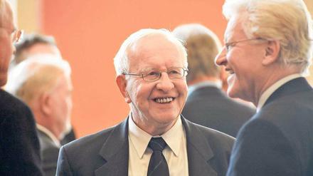 Ein älterer Mann ist im Gespräch mit anderen älteren Männern zu sehen.