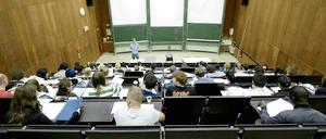 Ein junger Mann steht vor Studierenden im Hörsaal und spricht zu ihnen.