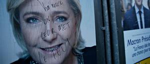 Ein beschmiertes Wahlplakat von Marine Le Pen vor einem Wahllokal in Lille.