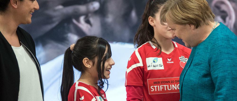 Willkommen war selten. Die Kanzlerin und eine junge Spielerin der Stiftung des 1. FC Köln "Wir zusammen"