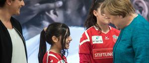 Willkommen war selten. Die Kanzlerin und eine junge Spielerin der Stiftung des 1. FC Köln "Wir zusammen"