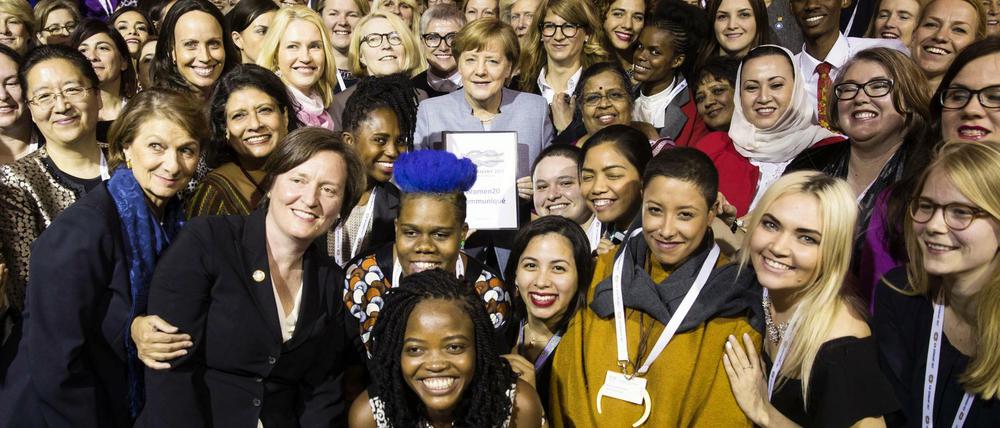 Teilnehmerinnen des W20-Gipfels posieren für ein Gruppenfoto mit Angela Merkel.