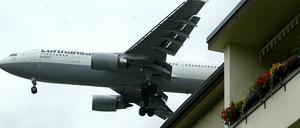 Eine Maschine Lufthansa fliegt über einem Haus im Berliner Stadtteil Reinickendorf zum Landeanflug auf den Flughafen Tegel.