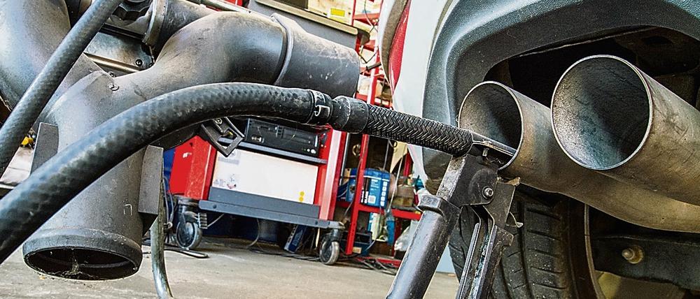 Die Sonde eines Geräts zur Abgasuntersuchung für Dieselmotoren steckt im Auspuffrohr eines Autos.