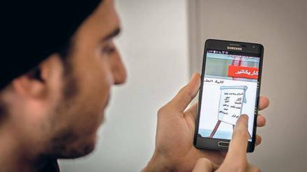 Ihr Werkzeug. Über Handy halten sie Kontakt zu den Reportern vor Ort.