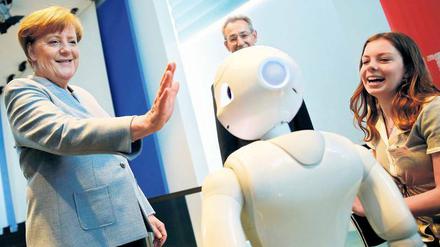 Bundeskanzlerin Angela Merkel übt sich im Kanzleramt beim Girls Day im Umgang mit Robotern. Die Veranstaltung soll technische Berufe für Mädchen interessanter machen. 