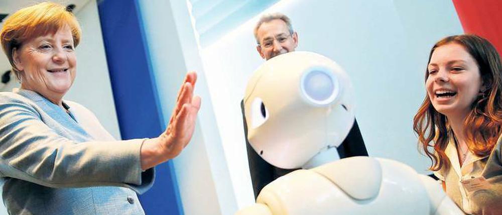 Bundeskanzlerin Angela Merkel übt sich im Kanzleramt beim Girls Day im Umgang mit Robotern. Die Veranstaltung soll technische Berufe für Mädchen interessanter machen.