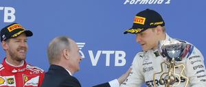 Da gratuliert der König persönlich. Russlands Präsident Wladimir Putin mit Valttteri Bottas (rechts), Sebastian Vettel freut sich derweil (links).