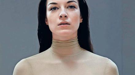 Ein Model trägt ein Oberteil aus Latex in Hautfarben.