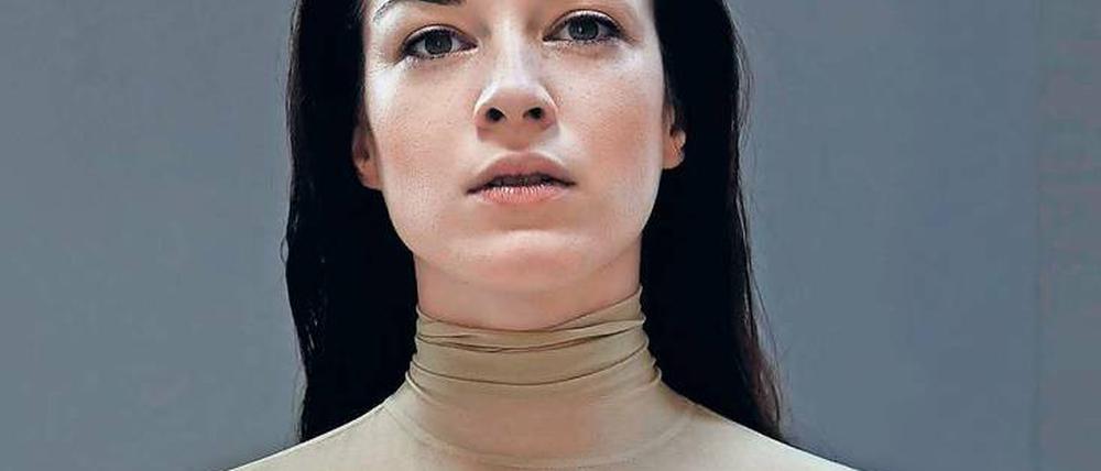 Ein Model trägt ein Oberteil aus Latex in Hautfarben.