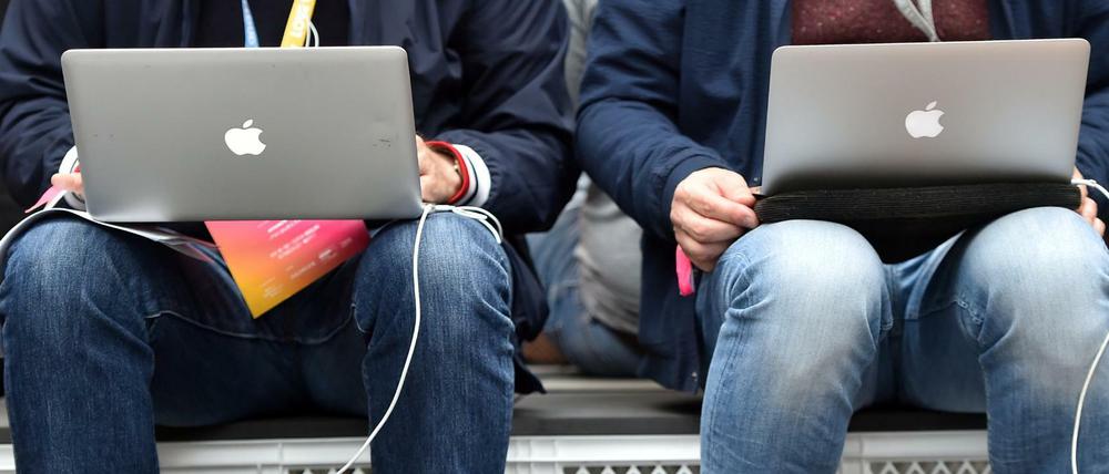 Konferenzteilnehmer sitzen auf der Internetkonferenz re:publica an ihren Laptops.