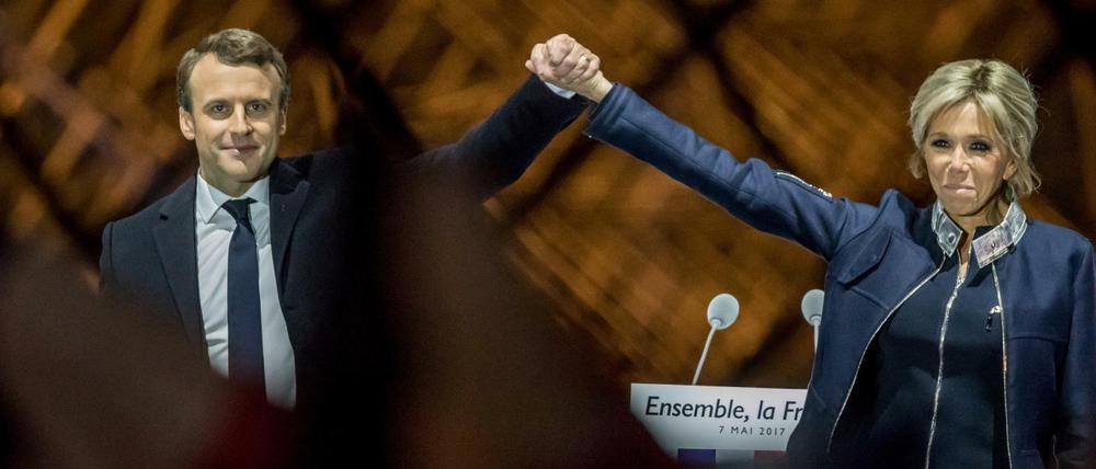 Emmanuel Macron steht nach dem Sieg bei der Präsidentenwahl mit seiner Ehefrau Brigitte auf einer Bühne am Louvre in Paris.